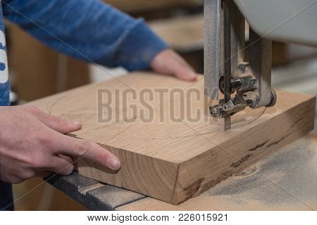 Carpenter Cuts Wood Piece With A Bench Saw - Close-up