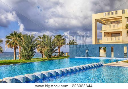 Pathos, Cyprus - January 12, 2018: Hotel Swimming Pool, Palm Trees And Beautiful Sea View, Pathos, C
