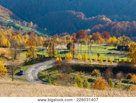 Unrecognizable Car On Dirty Secondary Road To Mountain Pass In Autumn Carpathian Mountains And Multi