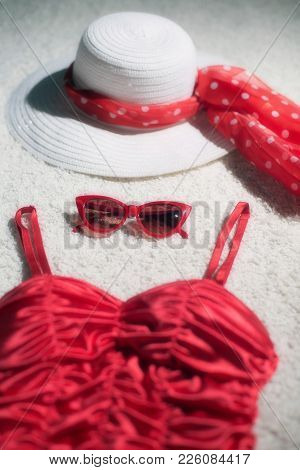 Vintage Summer Hat, Red Sunglasses And Swimsuit Displayed On White Carpet Floor.
