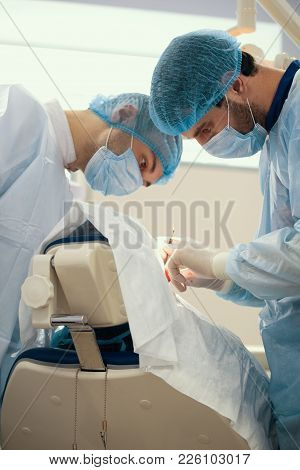 Two Surgeons In Blue Robes Make Operation In Surgery Room, Close Up