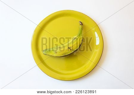 Half Ripe Burro Banana On Bright Green Plate, Also Orinoco, Bluggoe, Horse, Hog Or Largo Banana, Iso
