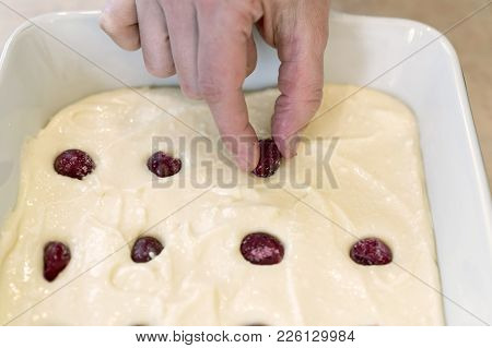 A Woman Is Adding Frozen Cherries To A Pie 1