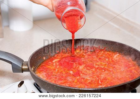 Close Up Hand Adds Tomato Paste To Roasted Carrot And Cabbage For Borscht, Vegetable Soup