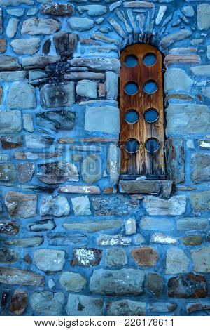 Narrow Wooden Window In Stone Wall Of Beautiful Medieval Christian Zelenchuk Church In Arkhyz. View 
