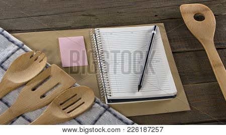 Wooden Kitchen Appliances Napkin And Notebook, On A Wood Background.