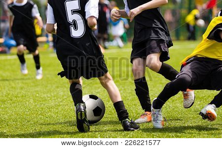 Soccer Players Competing For The Ball. Primary School Football Game. Soccer Tackle. Youth Soccer Tea