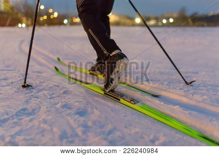 Photo From Back Of Skier With Sticks On Background Of Burning Lights In Winter Day