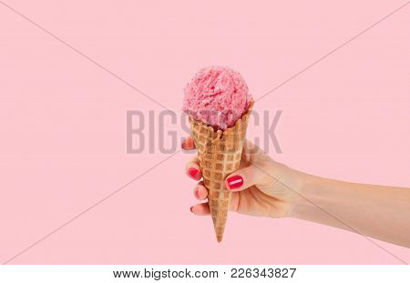 Hand Holding Strawberry Ice Cream Cone On Pink Faded Pastel Color Background. Strawberry Ice Cream I