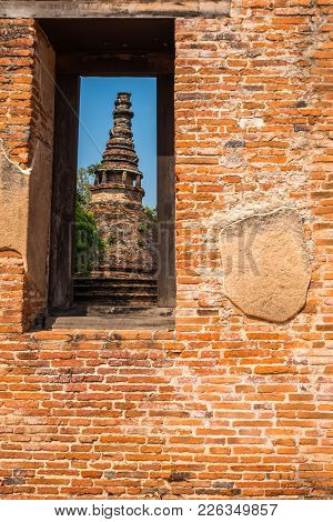 Ancient Old Pagoda At Mahaeyong Buddhist Temple In Window Of Brick Wall In Clear Sky Day In Ayutthay
