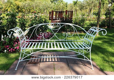A White Iron Bench In The Park