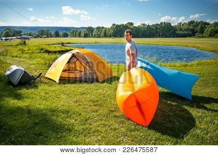 Man Setting Up Inflatable Sofas Out In The Wild Camping