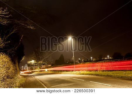 The Red Lights Of The Traffic As It Rushes By At Night