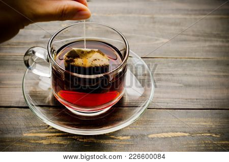 Hand Holding Tea Bag And Making Hot Tea