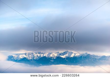 Beautiful Landscape Of A Mountain Crest Covered In Snow In The Clouds, Pestera, Bucegi, Romania