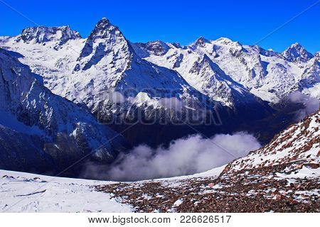 Unapproachable Sharp Rocks Covered With White Snow And The Blue Sky