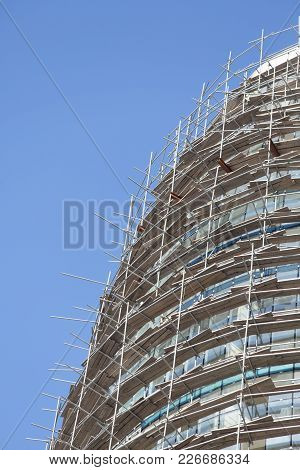Falsework On A Facade Of The New Under Construction House Against The Blue Sky.