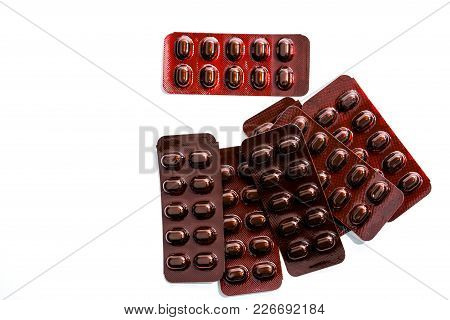 Pile Of Tablets Pills Medicine In Light Resistant Blister Pack On White Background . Vitamins And Mi