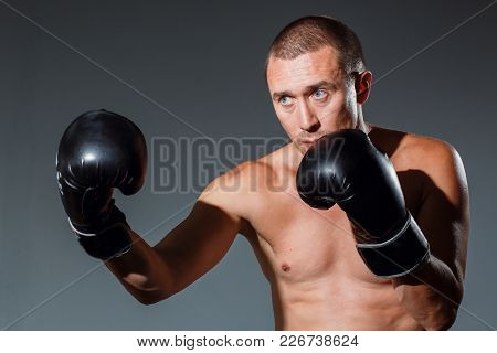 Sporty Man During Boxing Exercise Making Direct Hit