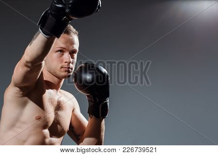 Sporty Man During Boxing Exercise Making Direct Hit