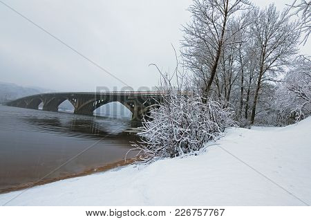 Beautiful Winter Landscape Photo. Metro(subway) Bridge Reflected In The Dnipro River. Snow Covers Tr