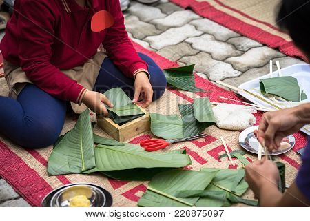 Child Wear Traditional Dress Ao Dai Learning To Make Chung Cake By Hands Closeup, Chung Cake Is The 