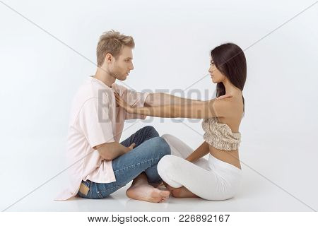 Young Mixed-race Couple Practicing Yoga Indoors On White Background. Young Asian Woman And Caucasian