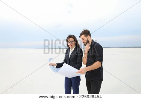 Designer Man And Representative Of Investment Company Woman Holding Whatman Paper With Plan, People 