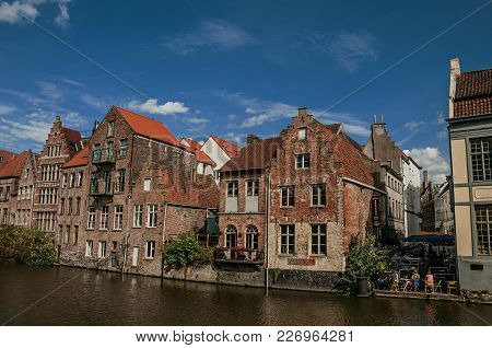 Ghent, Belgium - July 03, 2017. Old Buildings In Front Of The Canal And People In Ghent. In Addition