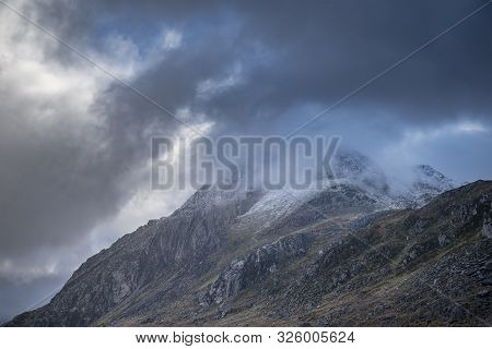 Stunning Moody Dramatic Winter Landscape Image Of Snowcapped Tryfan Mountain In Snowdonia During Sto