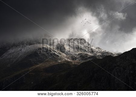 Stunning Moody Dramatic Winter Landscape Image Of Snowcapped Tryfan Mountain In Snowdonia During Sto