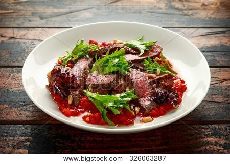 Beef Steak With Romesco Sauce, Nuts And Vegetables On White Plate