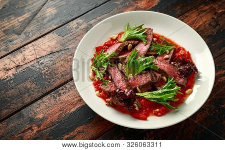 Beef Steak With Romesco Sauce, Nuts And Vegetables On White Plate