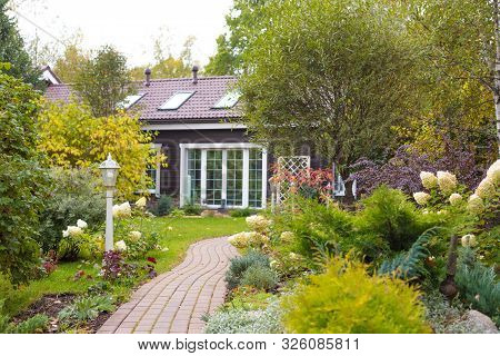 Beautiful Early Autumn Garden With Cottage House On The Background. Toned.