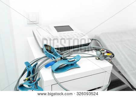 Sensors Electrodes With Suction Cups And Clothespins Are On The Table Near The Device, In The Ecg Of