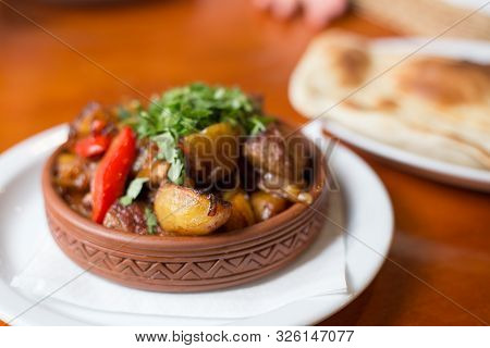 Roasted Meat With Potatoes, Ojaxuri, Hot In Georgian On A Wooden Table. Georgian Cuisine