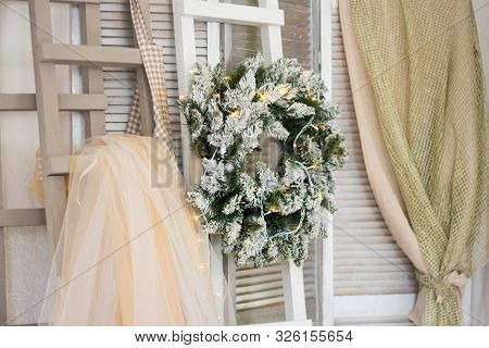 Green Christmas Wreath Decorated With Balls, Lights And Pinecones On An Old Vintage Planked White Wo