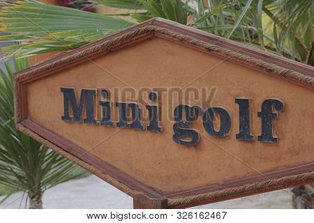 Signpost Mini Golf. A Sign Indicating Mini Golf. Enter The Public Park, Pointing The Way. Wooden Sig