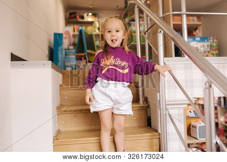 Happy Little Girl Walkning In Toy Store. Cute Girl Choose Toy. Adorable Female In Kids Mall