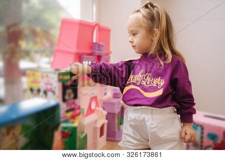 Happy Little Girl Walkning In Toy Store. Cute Girl Choose Toy. Adorable Female In Kids Mall