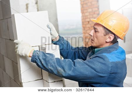 pedreiro de trabalhador de pedreiro de construção instalar tijolo de silicato de cálcio durante a criação da parede interior