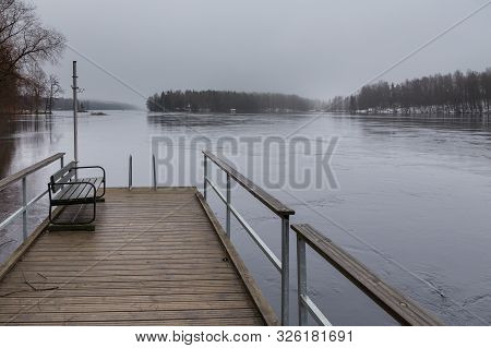 Small Pier At Beach On Lake Ruotsalainen, Bench On A Pier. Winter Landscape, Heinola, Finland.