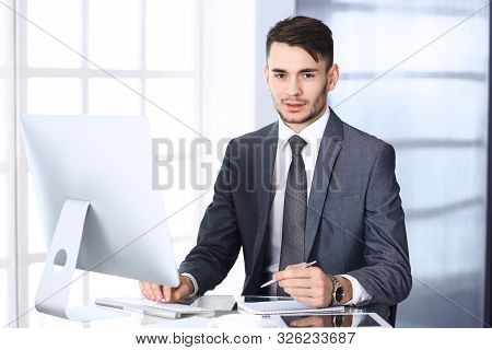 Businessman Working With Computer In Modern Office. Headshot Of Arab Male Entrepreneur Or Manager At