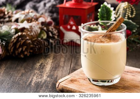 Homemade Eggnog With Cinnamon In Glass On Wooden Table. Typical Christmas Dessert. Copy Space