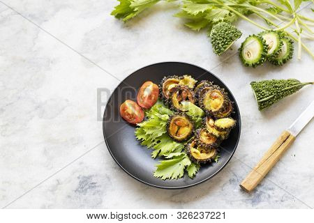 Top View. Pieces Of Fried Bitter Gourd Served With Lettuce Leaves On A Marble Table. Exotic Spicy Sn