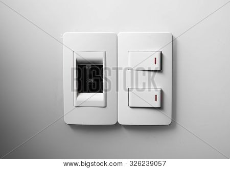 White Switch On A White Wall With Two Switches And One Common Switch.