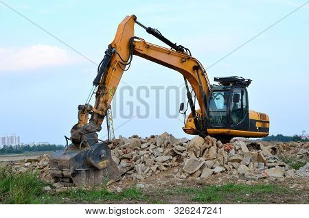 Excavator With Crusher Bucket For Crushing Concrete. Construction Waste Recycling For Construction M