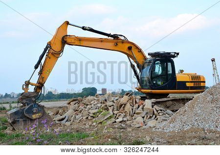 Excavator With Crusher Bucket For Crushing Concrete. Construction Waste Recycling For Construction M