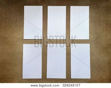 Six White Blank Business Cards Laid Out On A Brown Vintage Surface. Vertical Visiting Cards Of Desig