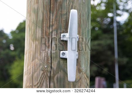 Close Up To A Metalic Boat Cleat On  Wood Dock Pier